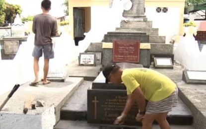 <p>People cleaning tombs during 'Undas'.<em> (File photo)</em></p>
