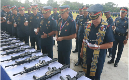 <p><strong>NEW FIREPOWER</strong>. Director Jose Maria Victor DF Ramos of the Philippine National Police (PNP) Directorate for Logistics (wearing the guest-of-honor welcome medal) with Calabarzon police Regional Director Chief Supt. Edward E Carranza (third from right) join Rev. Fr. Julius B. Cruz, Calabarzon PNP Regional Pastoral Officer,  in the blessing of some 490 Galil 5.56 rifles; 74 thermal imagers and 26 Global Positioning System (GPS) navigation devices including a Toyota Coaster that were turned over to the regional police force at the regional headquarters grandstand on Nov. 5, 2018. <strong><em>(Photo courtesy of PRO4A-RPIO)</em></strong></p>