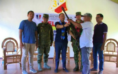 <p><strong>SURRENDER RITE.</strong> Maguindanao Governor Esmael Mangudadatu (center) accepts a rifle surrendered by one of nine Bangsamoro Islamic Freedom Fighters operating in the province’s Gen. Salipada K. Pendatun town during a turnover ceremony held at the headquarters of the Army’s 33rd Infantry Battalion in nearby President Quirino, Sultan Kudarat province. <em><strong>(Photo by 6ID)</strong></em></p>