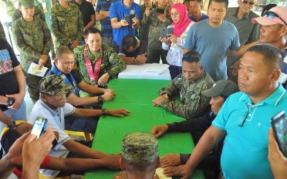 <p><strong>SETTLED.</strong> Members of the Pandapatan and Ayup families swear before the Quran on Thursday (Nov. 8, 2018) during a thanksgiving event held at the headquarters of the Army’s 33rd Infantry Battalion in President Quirino town of Sultan Kudarat province. (<em><strong>Photo by 33rd IB)</strong></em></p>