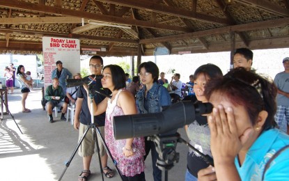 <p><strong>BIRD WATCHERS.</strong> Tourists peek through telescopes provided by bird watching enthusiasts at the view deck in Nagbacalan village at Paoay Lake, where migratory birds, especially the Great Cormorant, regularly come by every November. (<em>File photo courtesy of Tourism Ilocos Norte)</em></p>