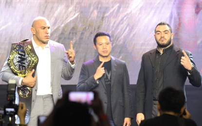 <p><strong>TITLE FIGHT.</strong> Defending heavyweight champion Brandon Vera of the Philippines (left) and challenger Mauro Cerilli of Italy pose during the ONE Championship "Conquest of Champion" press conference at the City of the Dreams ballroom in Paranaque City on Tuesday (November 20, 2018). At center is Hua Fung Teh, ONE Championship grouo chief financial officer and chairman of Greater China. (PNA photo by Jess M. Escaros Jr.)</p>