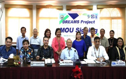 <p>DREAMS FOR RENEWAL ENERGY IN PALAWAN. Mylene Capongcol (2nd from left), OIC director of the Renewable Energy Management Bureau (REMB) and national project director of the DOE DREAMS; DOE Undersecretary Felix William Fuentebella (3rd from left); Palawan Governor Jose Alvarez; and Titon Mitra, country director of the United Nations Development Programme (UNDP) pose for a photo with the mayors of the five municipal pilot sites for DREAMS in Palawan after the signing of the MOU on November 28, 2018. <em>(Photo courtesy of the Palawan Provincial Information Office)</em></p>