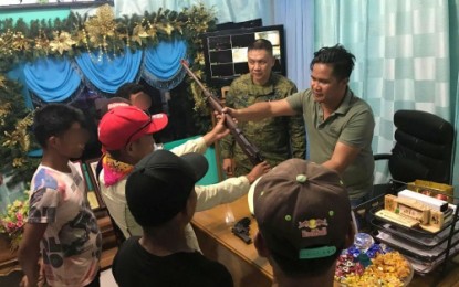 <p><strong>SURRENDER</strong>. Senator Ninoy Aquino Mayor Randy Ecija Jr receives a rifle during ceremonial surrender Friday (Nov. 30) from one of the six NPAs who surrendered to Army in Sultan Kudarat. <em><strong>(Photo courtesy of 33rd IB)</strong></em></p>