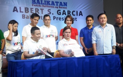 <p><strong>ALLIANCE.</strong> Davao City Mayor Sara Duterte, chair of Hugpong ng Pagbabago and Bataan Governor Albert Garcia, president of Partido Balikatan ng Bataan, sign an alliance agreement witnessed by some senatorial candidates and local officials at the Subic Bay International Convention Center on Sunday, Dec. 2, 2018. <em>(Photo by Ernie Esconde)</em></p>