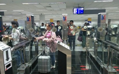 <p><strong>PASSENGER VOLUME.</strong> Arriving passengers utilize the electronic gates at the Ninoy Aquino International Airport Terminal 3 in Pasay City in this undated photo. From an average 130,000 daily passengers during the Christmas season in 2019, the figure is expected to reach up to 145,000 starting Dec. 22, 2023. <em>(PNA photo by Cristina Arayata)</em></p>