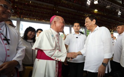 <p><strong>WARM GREETINGS.</strong> President Rodrigo Duterte shakes hands with Catholic church officials led by Catholic Bishops Conference of the Philippines President and Davao Archbishop Romulo Valles before the handover of the Balangiga bells in Balangiga, Eastern Samar on Saturday (December 16, 2018). The gesture earned cheers from the crowd. <em>(Photo courtesy of PPD)</em></p>