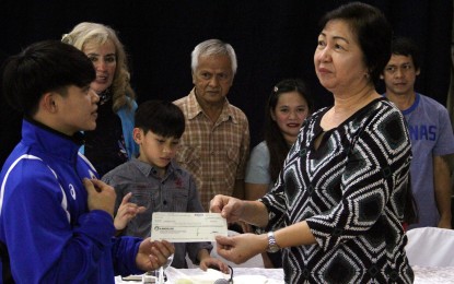 <p><strong>PINOY PRIDE</strong>. Gymnast Carlos "Caloy" Yulo (left) receives a check worth PHP250,000 from Philippine Sports Commission (PSC) Commissioner Celia Kiram during a press conference at the Gymnastics Association of the Philippines (GAP) training center inside the Rizal Memorial Sports Complex in Malate, Manila on Friday (Dec. 28, 2018). The amount is the incentive for Yulo's bronze medal at the world championships in Qatar last February. <em>(PNA photo by Jess Escaros)</em></p>