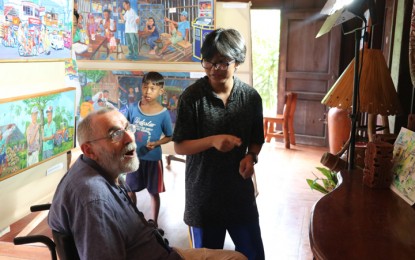 <p>David Joe Brutton, 67, a British cinematographer, introduces paintings as "social documents" in Dapitan City as residents mark the 122nd death anniversary of Dr. Jose Rizal. <em>(Photo by Gualberto M. Laput)</em></p>