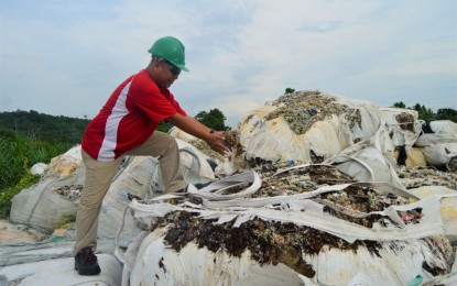 <p>Verde Soko Philippine Industrial Corp. project engineer Nathaniel Carampatana checks the shredded plastics that they will use as raw materials for the company’s recycling facility in Sitio Buguac, Barangay Santa Cruz, Tagoloan town in Misamis Oriental province. <em>(Photo by Jigger J. Jerusalem)</em></p>