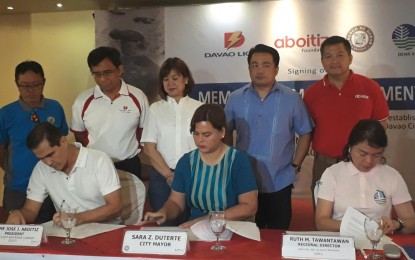 <p>(Seated from left) Jim Aboitiz, the president of Davao Light and Power Company, Mayor Sara Duterte and Executive Regional Director Ruth Tawantawan of the Department of Environment and Natural Resources sign the Memorandum of Agreement on the establishment of Pawikan Center at the Cleanergy Park, Punta Dumalag, Davao City. <em>(PNA Photo by Lilian C Mellejor)</em></p>