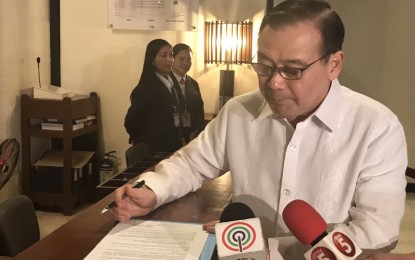 <p><strong>NO MORE BIRTH CERTIFICATES</strong>. Foreign Affairs Secretary Teodoro Locsin Jr. signs an order no longer requiring birth certificates in passport renewals. <em>(Photo courtesy of Willard Cheng)</em></p>