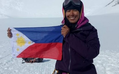 <p>Carina Dayondon bears the Philippine flag in one of her conquests reaching the peak.<em> (Photo from Carina Dayondon's social media post)</em></p>