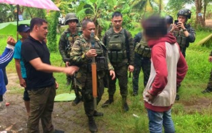 <p><strong>CHILD WARRIOR SURRENDERS.</strong> A minor, identified only as ‘Tigre’ (right), hands over a rocket-propelled grenade launcher to Lt. Col. Harold Cabunoc (left), commander of the Army’s 33rd Infantry Battalion, following his surrender on Saturday (Jan. 26) in Barangay Makainis, Gen. Salipada K. Pendatun, Maguindanao. <em>(Photo courtesy of 6th ID)</em></p>