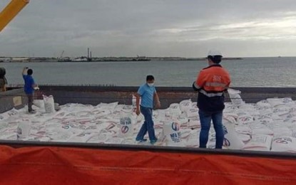 <p><strong>IMPORTED RICE.</strong> National Food Authority Grains Operations Officer III Roem Precioso (right) inspects the bags of imported rice from Vietnam unloaded at the Bredco port in Bacolod City.<em> (Photo courtesy of NFA-Negros Occidental)</em></p>