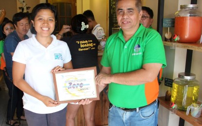 <p><strong>WASTE-FREE.</strong> Ida Vecino, social enterprise officer of Wala Usik Tiangge+Kapehan, receives the certificate of recognition from Community Environment and Natural Resources-Bago City chief Joan Nathaniel Gerangaya, acknowledging their zero-waste advocacy during the DENR personnel’s visit to the store on Tuesday (Jan. 29, 2019).<em> (Photo courtesy of CENRO Bago City)</em></p>
<p> </p>