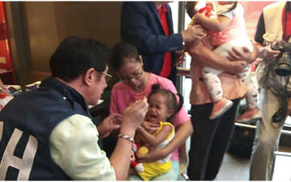 <p><strong>MEASLES VACCINE.</strong> Department of Health Region IV-A (Calabarzon) Regional Director Eduardo Janairo administers a measles vaccine to one of the children. The DOH has intensified its immunization campaign to curb the increasing number of measles cases in the country. <em>(Photo courtesy of DOH)</em></p>