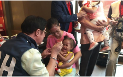 <p>Parents of some 20 children aged three to 10 years-old dining at a Jollibee fast food chain in Bayan, Barangay Sto. Niño, Biñan City in Laguna express joy as the Department of Health (DOH) Calabarzon task force led by Regional Director Dr. Eduardo C. Janairo administers the mass vaccination against the infectious measles disease on Feb. 12, 2019. <em>(Photo by Robert A. Maico)</em></p>