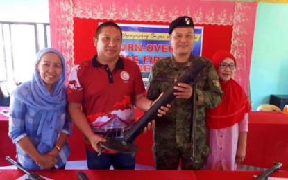 <p><strong>SURRENDERED.</strong> Lt. Colonel Alvin Iyog, Army’s 2nd Mechanized Infantry Battalion commander, receives a 60mm mortar tube from Ampatuan, Maguindanao Mayor Rasul Sangki during the ceremonial turnover of 26 unlicensed firearms to the military on Thursday (Feb. 14). <em><strong>(Photo by 2nd MIB)</strong></em></p>