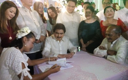 <p><strong>MASS WEDDING.</strong> Bacolod City Mayor Evelio Leonardia (seated, center) witnesses the signing of marriage contract by couple Ricardo Tomayao, 74, and Glaiza Cosme, 29, in the presence of other city officials during the mass wedding ceremony at the Bacolod City Government Center grounds on Sunday, Feb. 17, 2019. <em>(Photo by Nanette L. Guadalquiver)</em></p>
<p> </p>