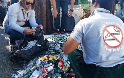 <p>Authorities lead the destruction of sacks of cigarette packs, worth around  PHP150,000, seized in 2018 during the implementation of City Ordinance 34 series 2017 or the “Smoke-free Baguio". <em>(PNA photo by Liza T. Agoot)</em></p>