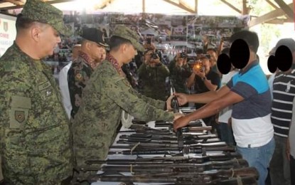 <p>Col. Benedict Arevalo, commander of the 303rd Infantry Brigade, receives a surrendered firearm of a former rebel during the ceremony held at the Philippine Army’s 79<sup>th</sup> Infantry Battalion headquarters in Barangay Bato, Sagay City on Saturday. <em>(Photo courtesy of 79<sup>th</sup> Infantry Battalion, Philippine Army)</em></p>