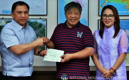 <p><strong>AID FOR 'ROSITA' VICTIMS. </strong>Mountain Province Governor Bonifacio Lacwasan receives the PHP5 million grant for the victims of Typhoon Rosita for the municipalities of Natonin and Paracelis from National Housing Authority (NHA) General Manager Marcelino Escalada Jr. Joining them in a simple ceremony is Presidential Communications Operations Office (PCOO) Assistant Secretary Marie Rafael. <em>(Photo by Roy Allan Ven Perdon)</em></p>