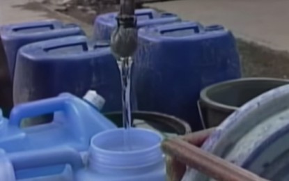 <p>A faucet filling a container with water. <em>(File photo)</em></p>
