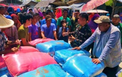 <p>Displaced families in Maguindanao listen as a soldier explains the mechanics of a relief distribution in Datu Salibo, Maguindanao on Tuesday. <em><strong>(Photo courtesy of BARRM-HEART)</strong></em></p>