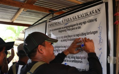 <p><strong>COMMITMENT.</strong> Forest and fire protection officers and members of the people's organization sign a commitment to protect the environment during the basic firefight and first aid training held in Barangay San Isidro, City of San Jose Del Monte, Bulacan on Thursday, March 21, 2019. <em>(Photo courtesy of the Department of Environment and Natural Resources-Region 3)</em></p>