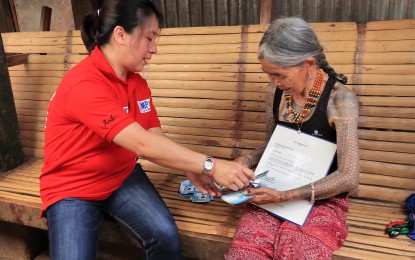 <p><strong>CENTENARIAN.</strong> Maria Oggay, popularly known as "Ina Whang-od", receives PHP100,000 cash gift and a letter of felicitation during her 100th birthday on March 7, 2019 at her residence in Buscalan, Tinglayan, Kalinga from a representative of the Department of Social Welfare and Development in Cordillera. <em>(Photo courtesy of DSWD-CAR Marketing Unit)</em></p>