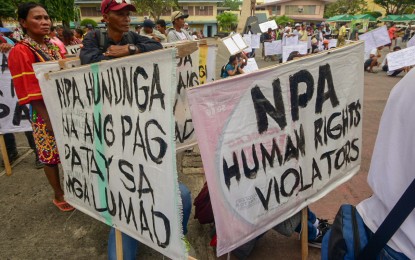 <p>Indigenous peoples from Davao City bring placards calling for protection from the New People's Army (NPA) atrocities during a peace rally at Rizal Park, Davao City on Friday. </p>