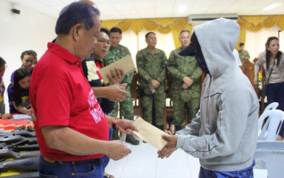 <p><strong>NPA SURRENDERERS.</strong> Sultan Kudarat Governor Pax Mangudadatu (left) hands over cash assistance to one of the 19 New People's Army (NPA) surrenderers in Sultan Kudarat on Friday (March 29, 2019).  The rebels belonged to different NPA fronts operating in the provinces of North Cotabato, Davao del Sur, Sultan Kudarat, and South Cotabato. <em>(Photo courtesy of 33rd IB)</em></p>