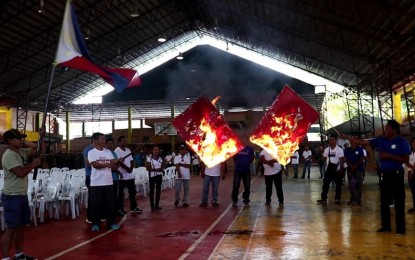 <p>Residents of Himamaylan City, Negros Occidental burn the Communist Party of the Philippines flags to condemn their presence and atrocities in a program held at Gatuslao Gymnasium on Friday (March 29, 2019). <em>(Photo courtesy of 62<sup>nd</sup> Infantry Battalion, Philippine Army)</em></p>
<p><em> </em></p>