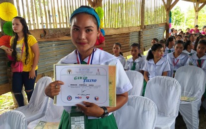 <p><strong>HONOR MOM.</strong> Roselyn Dagsa, 21, is one of the Grade 7 honor students of Buraburon National High School recognized for her achievements on Friday (April 5, 2019). In most school days, she brings her two-year-old kid to the classroom. Her story featured by the Philippine News Agency has inspired netizens. <em>(Photo by Sarwell Meniano)</em></p>