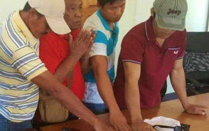<p><strong>SETTLED.</strong> Members of Bunsa and Mangalundong-Sampiano clans swear before the Holy Quran that they will no longer resort to violence to settle misunderstanding. <em><strong>(Photo by 6th IB)</strong></em></p>