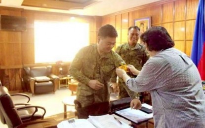 <p><strong>SECURITY TASK FORCE.</strong> Tacurong City Mayor Lina Montilla puts a Task Force Talakudong (Tacurong) put a patch on Colonel Pedro Balisi Jr.’s military uniform as 1st Mechanized Infantry Brigade Commander Colonel Efren Baluyot looks on at the mayor's office on Thursday. <em><strong>(1st MIB photo)</strong></em></p>