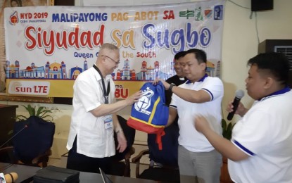 <p><strong>NATIONAL YOUTH DAY KIT.</strong> Cebu Archbishop Jose Palma (left) receives a colorful backpack as seminar kit for the National Youth Day 2019 in Cebu from the steering team head, Rev. Fr. Mark Rommel Barneso (second from right); festival sites manager, Rev. Fr. Joselito Gutierrez (in black clerical suit); and youth coordinator Frankel Gerard Margallo (right) during the press briefing at the Archbishop's Residence in Cebu City, on Friday (April 12, 2019). <em>(Photo by John Rey Saavedra)</em></p>