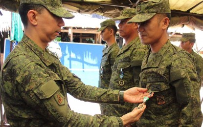 <p><strong>RECOGNIZED FOR BRAVERY.</strong> Brig. Gen. Benedict Arevalo, commander of 303<sup>rd</sup> Infantry Brigade, pins a Military Commendation Medal on a soldier of the 62nd Infantry Battalion during a ceremony held at the battalion headquarters in Isabela, Negros Occidental on Wednesday (April 25, 2019).  A total of 40 troopers of two Army battalions in Negros Occidental received the medals for fighting the communist rebels. <em>(Photo courtesy of 303<sup>rd</sup> Infantry Brigade, Philippine Army)</em></p>
