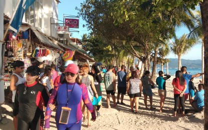<p><strong>ERRING ESTABLISHMENTS.</strong> Tourists walk past business establishments in the world-famous Boracay Island. The Boracay Inter-Agency Rehabilitation Management Group on Friday (July 19, 2019) started removing establishments that violate the 25+5 coastal easement in Bulabog Beach in Barangay Balabag, Malay, Aklan. <em>(File photo)</em></p>