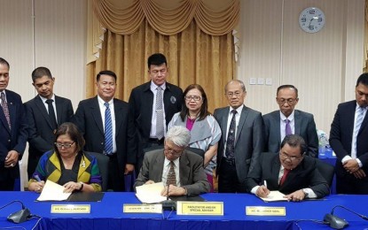 <p><strong>GPH-MILF PEACE PANELS: </strong> New Philippine government Implementing Panel  chair Gloria J. Mercado, MILF Implementing Panel chair Mohagher Iqbal and Malaysia facilator Dato' Kamarudin bin Mustafa a sign joint statement in a special meeting in Kuala Lumpur, Malaysia on April 29, 2019.  In the joint statement, members of the Philippine government and the Moro Islamic Liberation Front (MILF) Peace Implementing Panels reaffirmed their commitment to fully implement the Comprehensive Agreement on the Bangsamoro (CAB) and all GPH-MILF peace pacts. <em>(Photo courtesy of OPAPP)</em></p>
