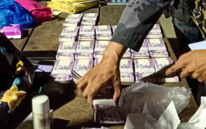 <p><strong>SUSPECTED VOTE BUYING MONEY.</strong> Policemen count the money allegedly used for vote buying in North Cotabato. At least four alleged supporters of the Taliño political clan in the province were caught in possession of the money on Friday night (May 10, 2019). The Taliño camp has denied the money was for vote buying, saying this was for watchers' pay. <em>(Photo courtesy of the M’lang Police)</em></p>