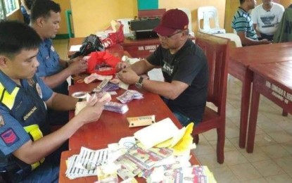 <p><strong>'VOTE-BUYING' INCIDENT. </strong>The Aguilar police and the National Bureau of Investigation office in Dagupan City arrest four persons for alleged vote buying at barangay Buer Aguilar on Sunday. Some PHP443,300 sum of money of different denominations and election paraphernalia were confiscated. <em>(Photo courtesy of Police Regional Office 1's facebook page)</em></p>