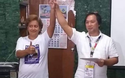 <p><strong>WINNER.</strong> Election officer Jesus Gaston proclaims Ella Celestina Garcia-Yulo (left) as the duly-elected mayor of Moises Padilla, Negros Occidental early Tuesday morning (May 14, 2019). The outgoing vice-mayor defeated her uncle,  reelectionist Mayor Magdaleno Peña. <em>(Photo courtesy of Grace Supe)</em></p>