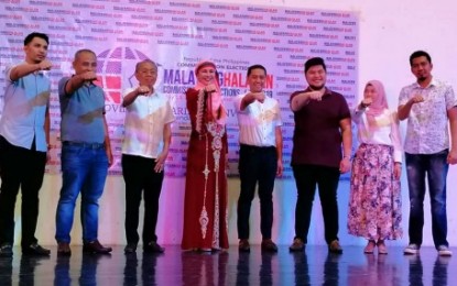 <p><strong>MAGUINDANAO LADY GOVERNOR.</strong> Election officials raised the hands of Maguindanao Governor-elect Bai Mariam Sangki-Mangudadatu (4th from left) on Thursday (May 16) at Shariff Kabunsuan Complex in Cotabato City together with the province’s Congressman-elect Datu Ronne Sinsuat (3rd from left), Vice Governor-elect Datu Lester Sinsuat, and several elected board members of the province. Sangki-Mangudadatu is the first-ever lady governor of the 46-year-old province. <em>(Photo courtesy of Ella Dayawan – Bandera Radio Cotabato)</em></p>