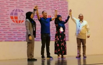 <p><strong>PROCLAIMED CONGRESSMAN.</strong> Members of the Maguindanao provincial board of canvassers on Thursday (May 16, 2019) raise the hands of outgoing Maguindanao Governor Esmael “Toto” Mangudadatu (2nd from left) who won as a congressman-elect for the province’s second district. Mangudadatu has called for reconciliation following the May 13 mid-term polls. <em><strong>(Photo courtesy of Ella Dayawan – Bandera Radio Cotabato)</strong></em></p>