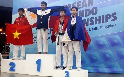 <p><strong>STANDING TALL.</strong> Baguio Boy Rama Chandra Liporada proudly raises the Philippine flag after bagging gold in the juniors -51 kilogram weight class of the 14th ASEAN Taekwondo Federation Championships held at the SM Mall of Asia Arena in Pasay City on May 4 to 5. In the picture are (from L to R) Vietnamese Huynh Ie Anh Tri , Liporada, Vietnamese Phan Tien Da and compatriot Kian Graydon Ashe. (Photo courtesy of PIO-City government)</p>