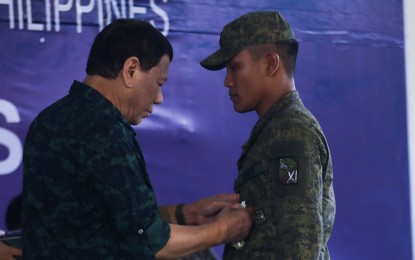 <p><strong>PRRD VISITS SULU.</strong> President Rodrigo R. Duterte confers the Gold Cross Medal on one of the troopers who made an exemplary act of valor during his visit to Camp Teodulfo Bautista in Jolo, Sulu on June 4, 2019. <em>(Presidential Photo)</em></p>