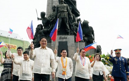 <p><strong>WAVING THE FLAG</strong>. Chief Justice Lucas Bersamin (3rd from right), leads the waving of miniature Philippine flags in front of the Andres Bonifacio Monument in Caloocan City on Wednesday (June 12, 2019). Joining him are Caloocan Mayor Oscar Malapitan (4th right), Vice Mayor Macario Asistio III (4th from left), and other officials. This year's Independence Day rite is themed: “Kalayaan 2019: Tapang ng Bayan, Malasakit sa Mamamayan”. <em>(PNA photo by Ben Briones)</em></p>