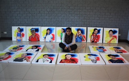 <p><strong>SPORTS HEROES</strong>. Artist Gladys Anne Labsan is surrounded by her portraits of Cordillera athletes for the show Heroes and Legends: Portrait of the Cordillera Athletes to be shown at the Baguio Museum from June 16 to July 7. The exhibit will feature 27 sports heroes from the Cordillera who carry the flag and the Philippines in international competitions. <em>(PNA photo by Pigeon M. Lobien)</em></p>